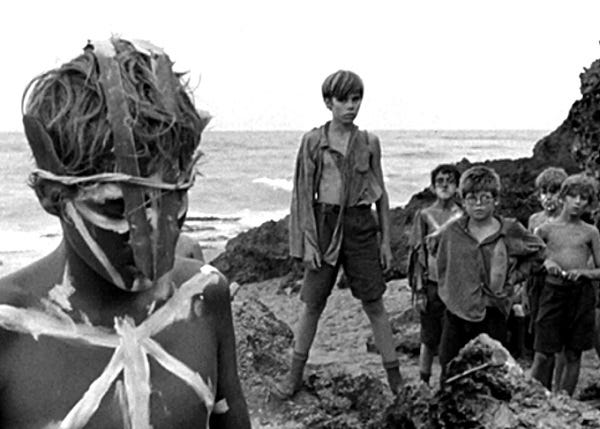 still image from lord of the Flies showing boys in rags and one withface painted