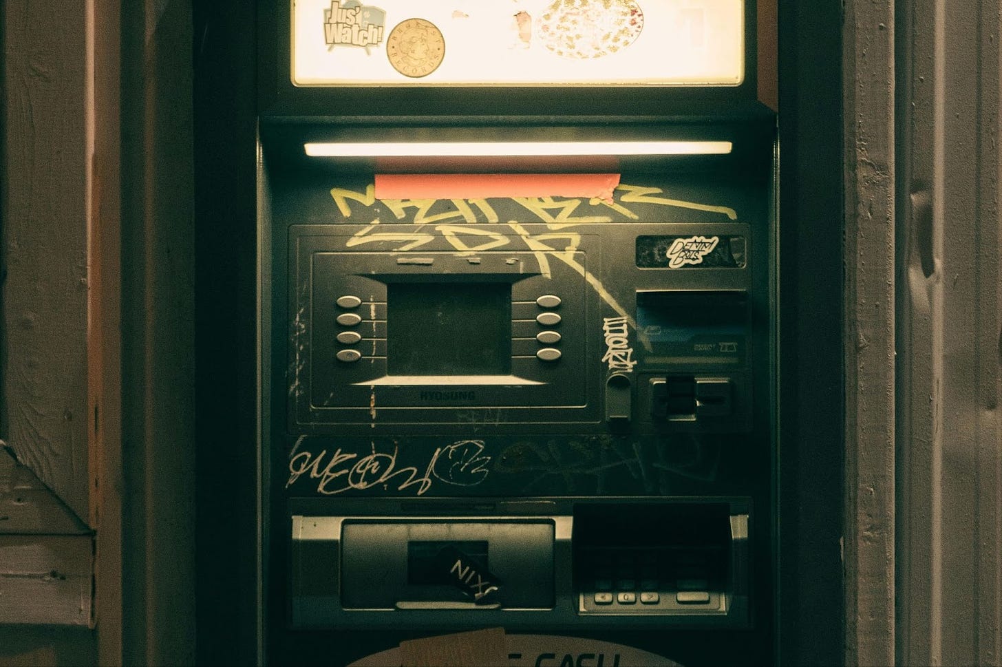 A broken cash machine tagged with graffiti