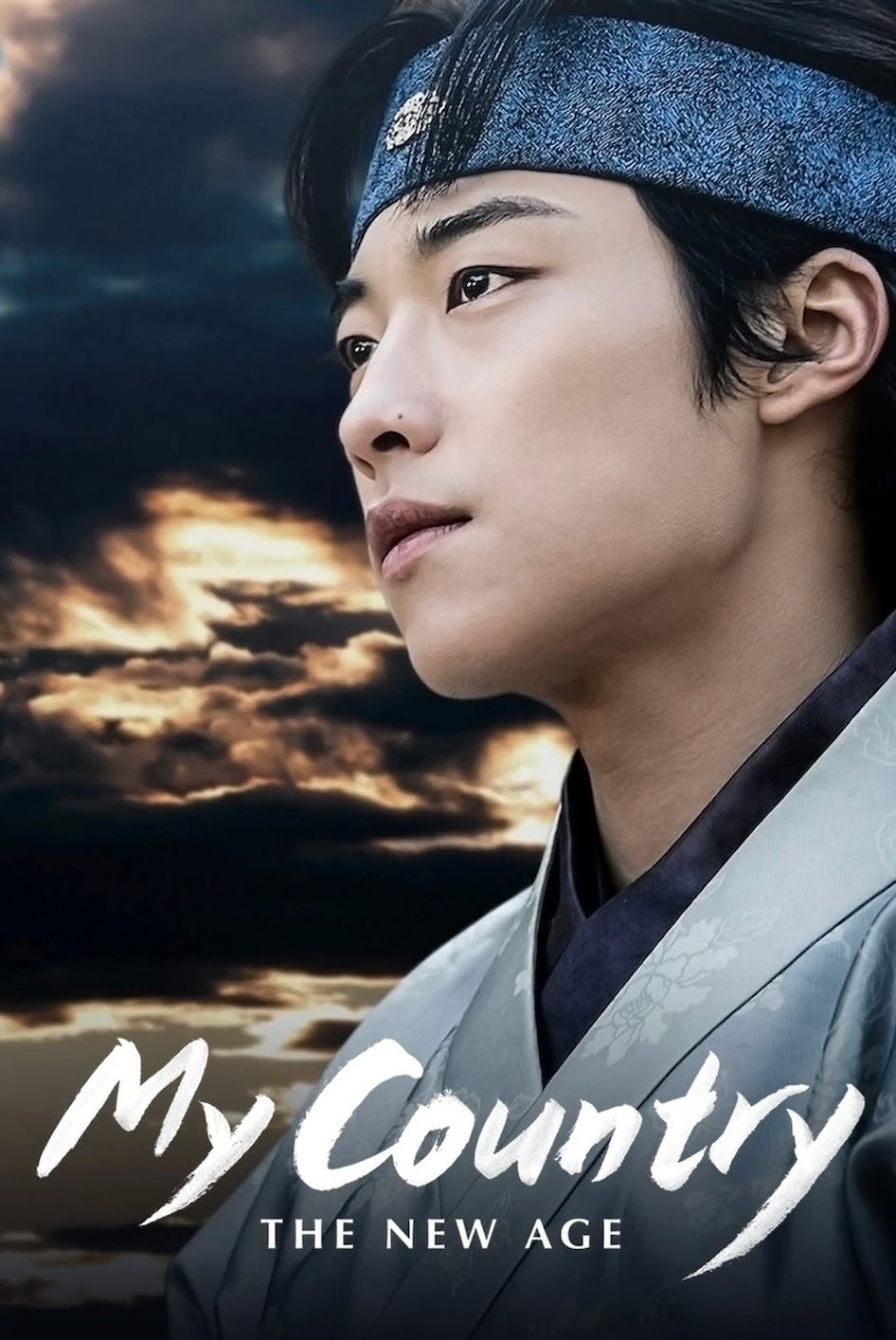 The poster for My Country: The New Age. Actor Woo Do Hwan is dressed in late Goryeo era clothing. He looks off in the distance with storm clouds brewing behind him.