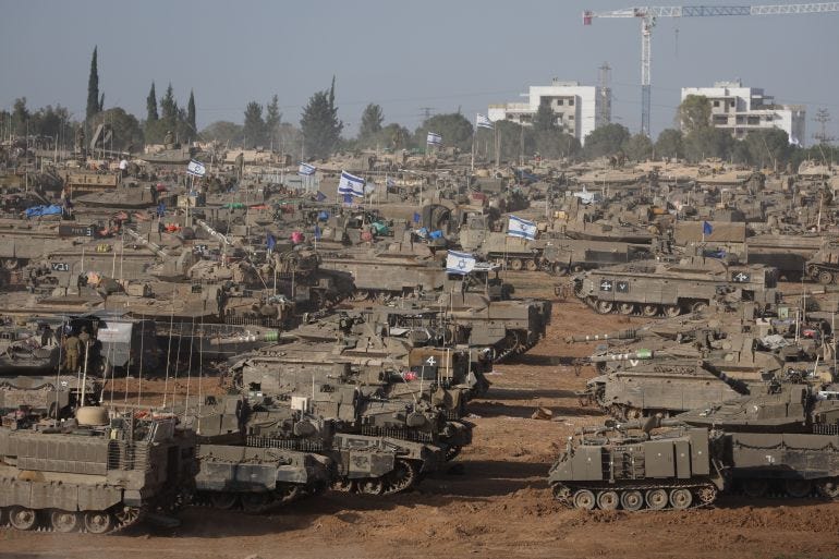 rows and rows of tanks some with israeli flags in a desert