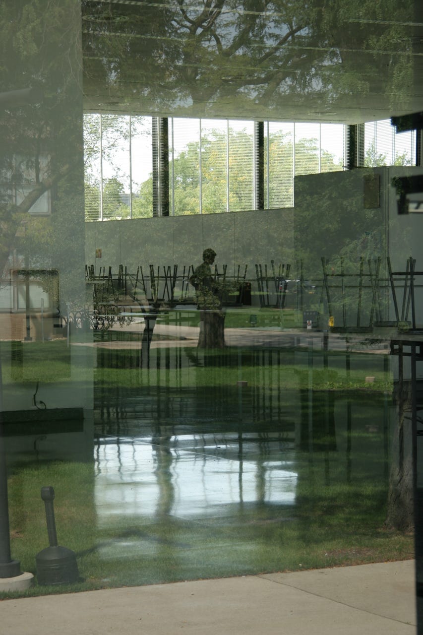 A reflection of a statue in a glass wall

Description automatically generated