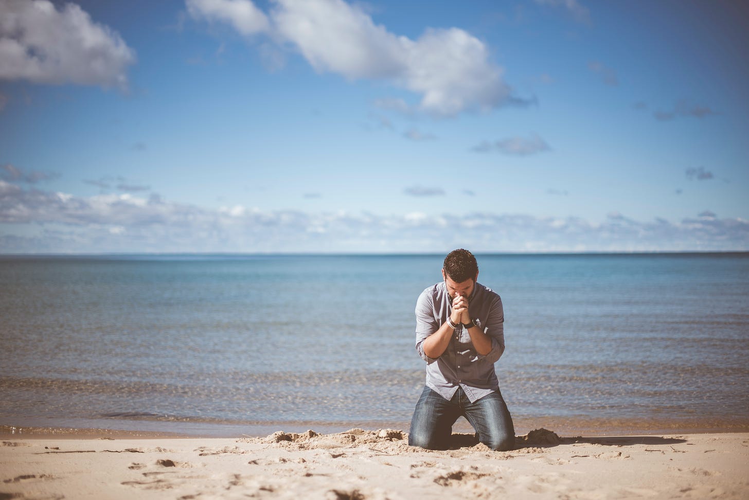 Man on beach praying