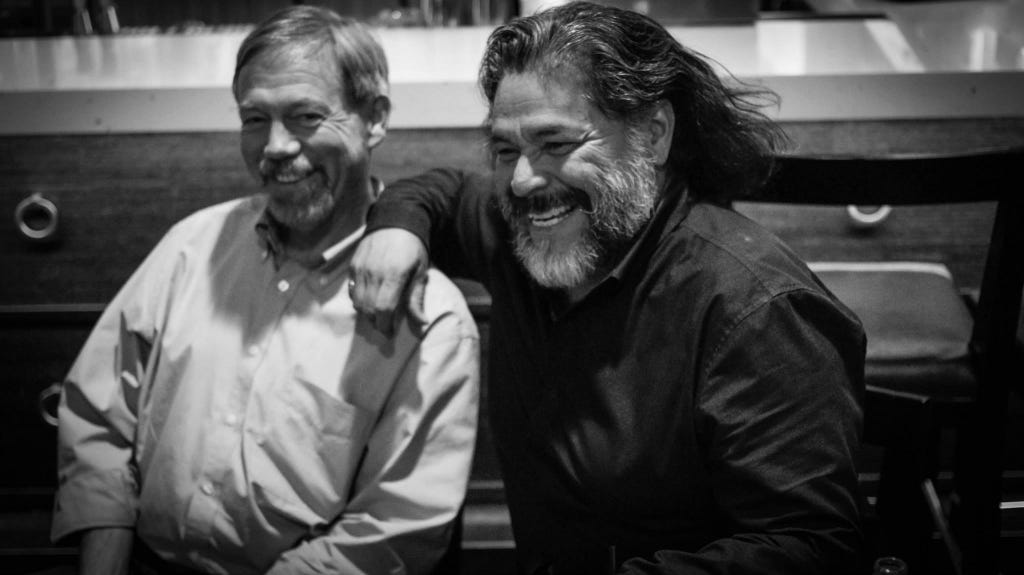 Toby Hemenway and Larry Santoyo enjoying a laugh over dinner. Photo credit Souki Mehdaoui.