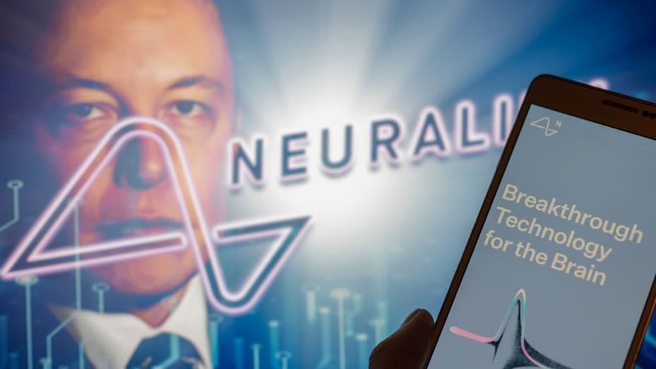 Neuralink logo displayed on mobil with founder Elon Musk seen on screen in the background. Neuralink Corporation is a neurotechnology company that develops implantable brain-computer interfaces. In Brussels on 4 December 2022. (Photo Illustration by Jonathan Raa/NurPhoto via Getty Images)