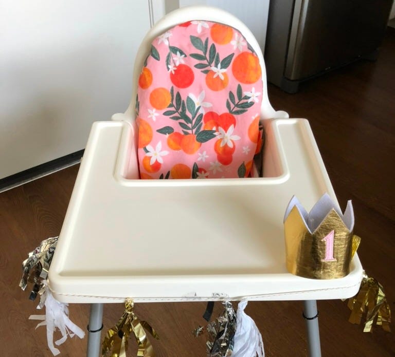 A photo of the Ikea Antilop high chair, decorated with tinsel and a birthday crown.