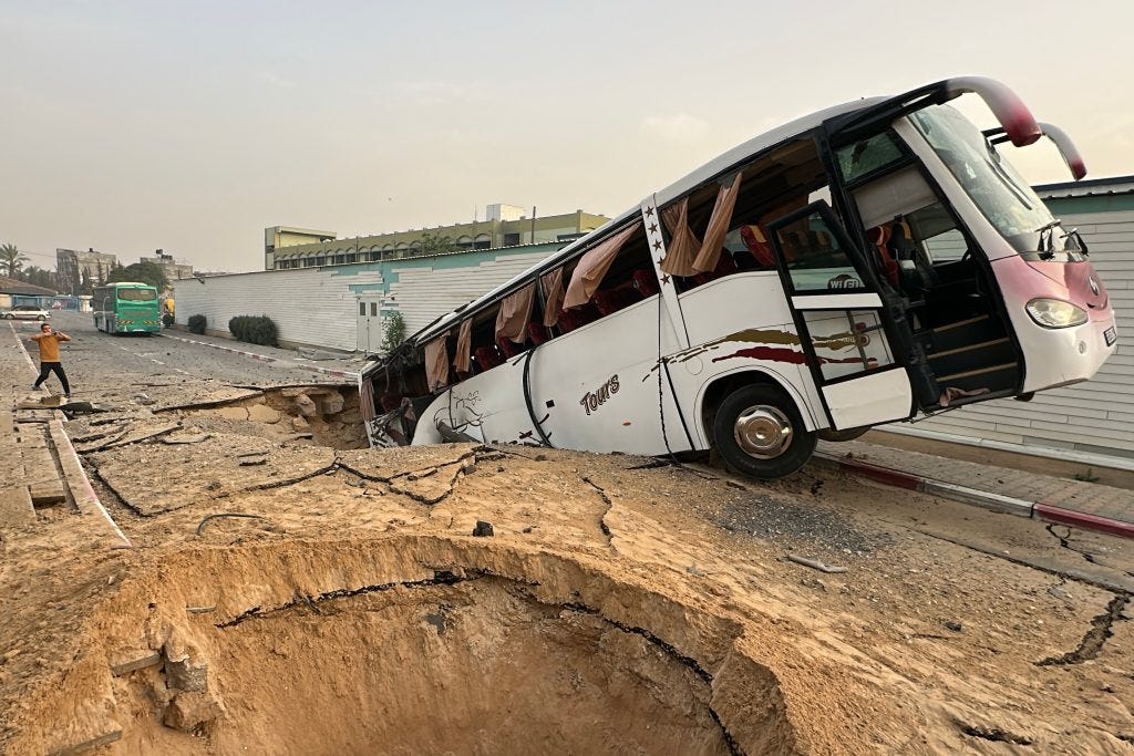 The rear end of a full-size bus is in a crater left from a bunker-buster bomb the Israeli military dropped on the European Hospital in Khan Younis, Gaza. The bus is heavily damaged and sits at an angle. Other similar craters are seen nearby. The photo was taken by Moaz Abu Taha for APA Images on May 13, 2025. The rear end of a full-size bus is in a crater left from a bunker-buster bomb the Israeli military dropped on the European Hospital in Khan Younis, Gaza. The bus is heavily damaged and sits at an angle. Other similar craters are seen nearby. The photo was taken by Moaz Abu Taha for APA Images on May 13, 2025.