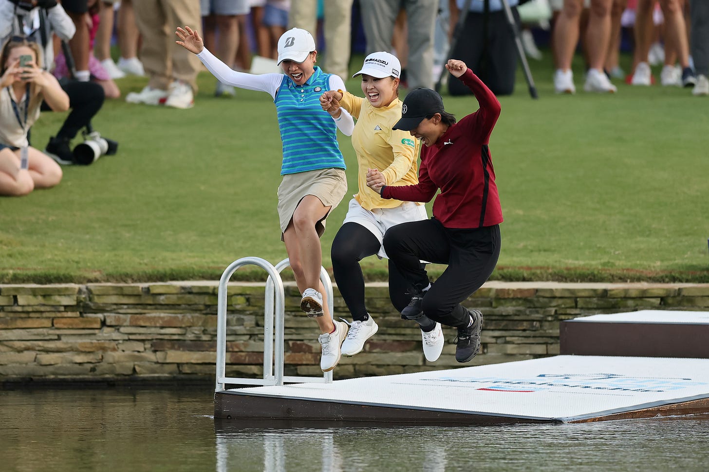 In one of golf’s more bizarre rituals, Mao Saigo of Japan (centre) jumps into the pond on the 18th at The Club at Carlton Woods after winning The Chevron Championship. In one of golf’s more bizarre rituals, Mao Saigo of Japan (centre) jumps into the pond on the 18th at The Club at Carlton Woods after winning The Chevron Championship.