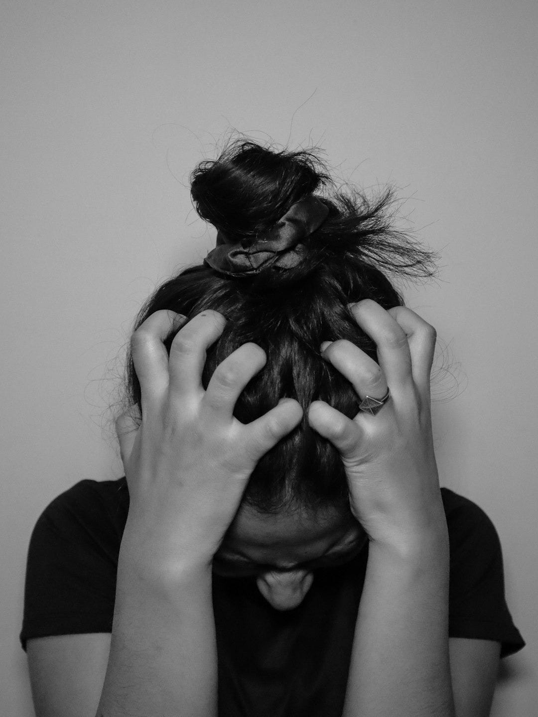 a woman covering her face with her hands a woman covering her face with her hands