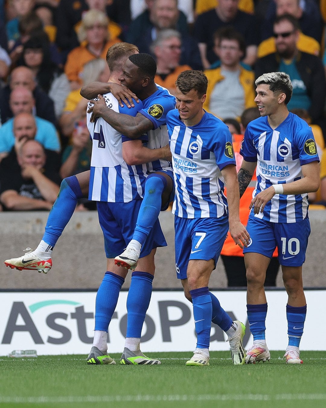 Pervis hugs Adam Webster after scoring against Wolves, with Solly and Julio smiling alongside them. Squad goals.