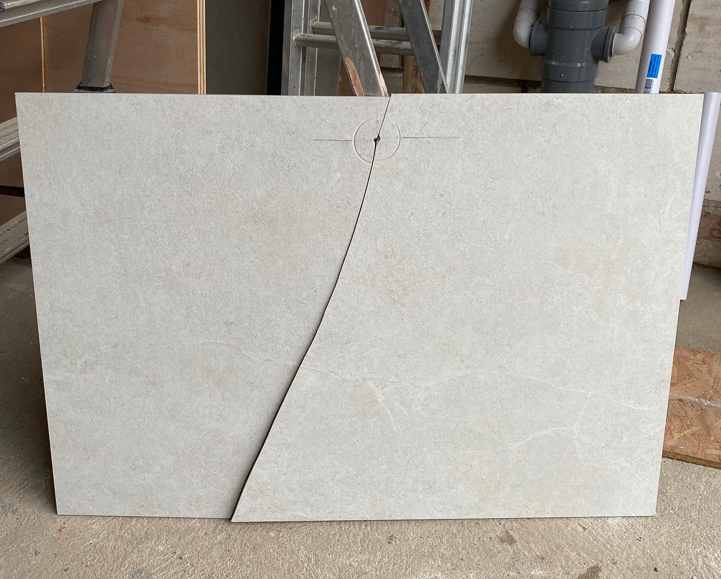 white tile with a large crack down the middle splitting it in two