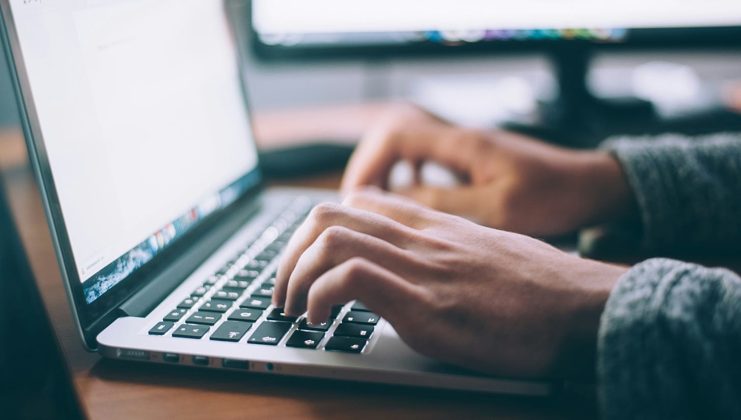 The hands of a person typing on a laptop