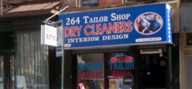 A street view of a tailor shop that also does dry cleaning and interior design, an ATM