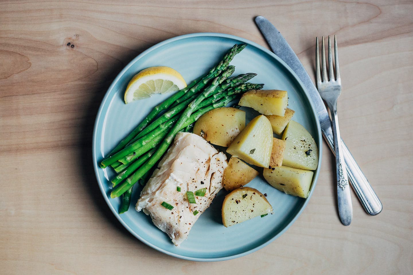 A plate with cod, asparagus, and potatoes