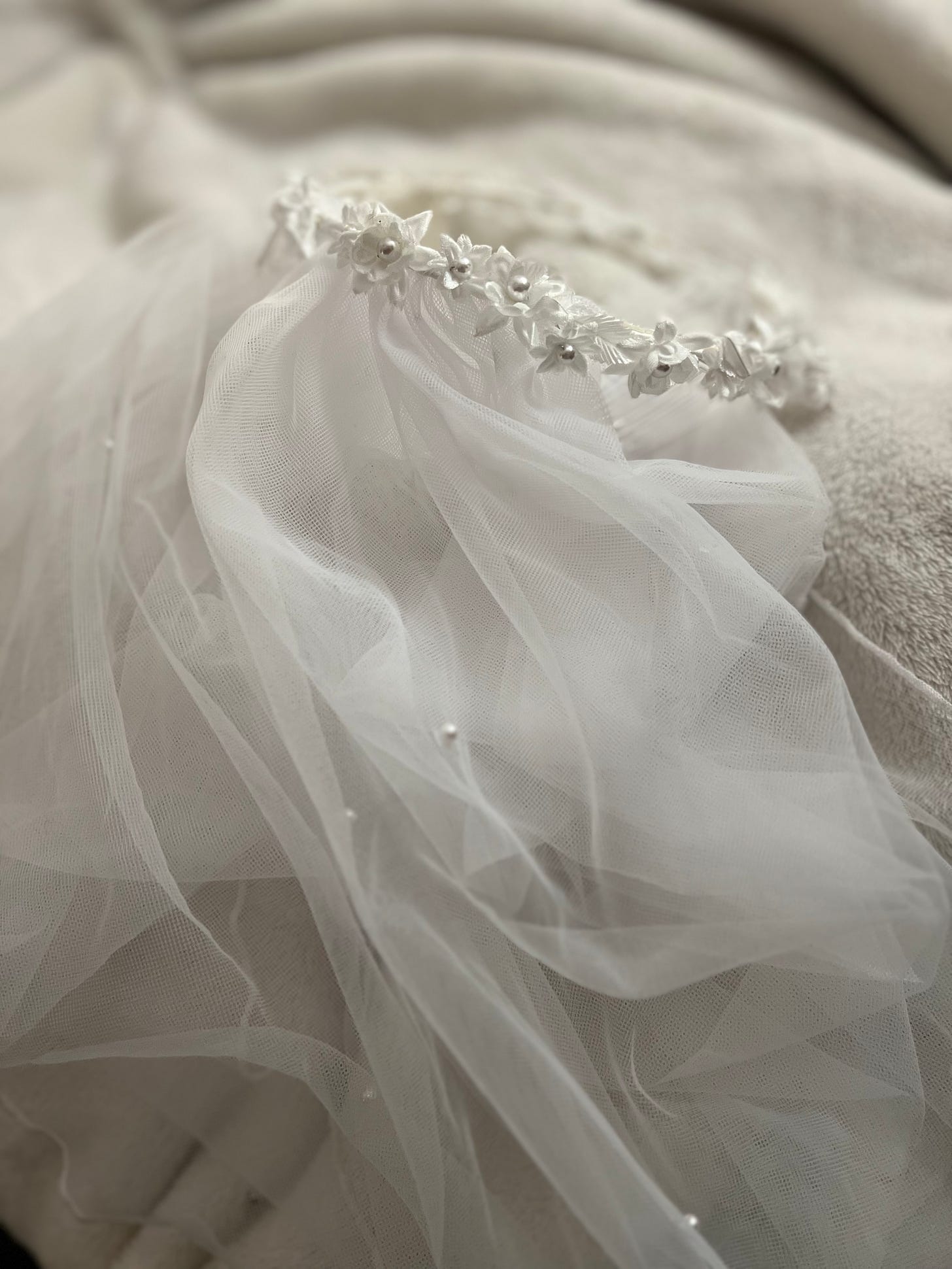 Photo of headband with flowers and pearls attached to tulle veil.