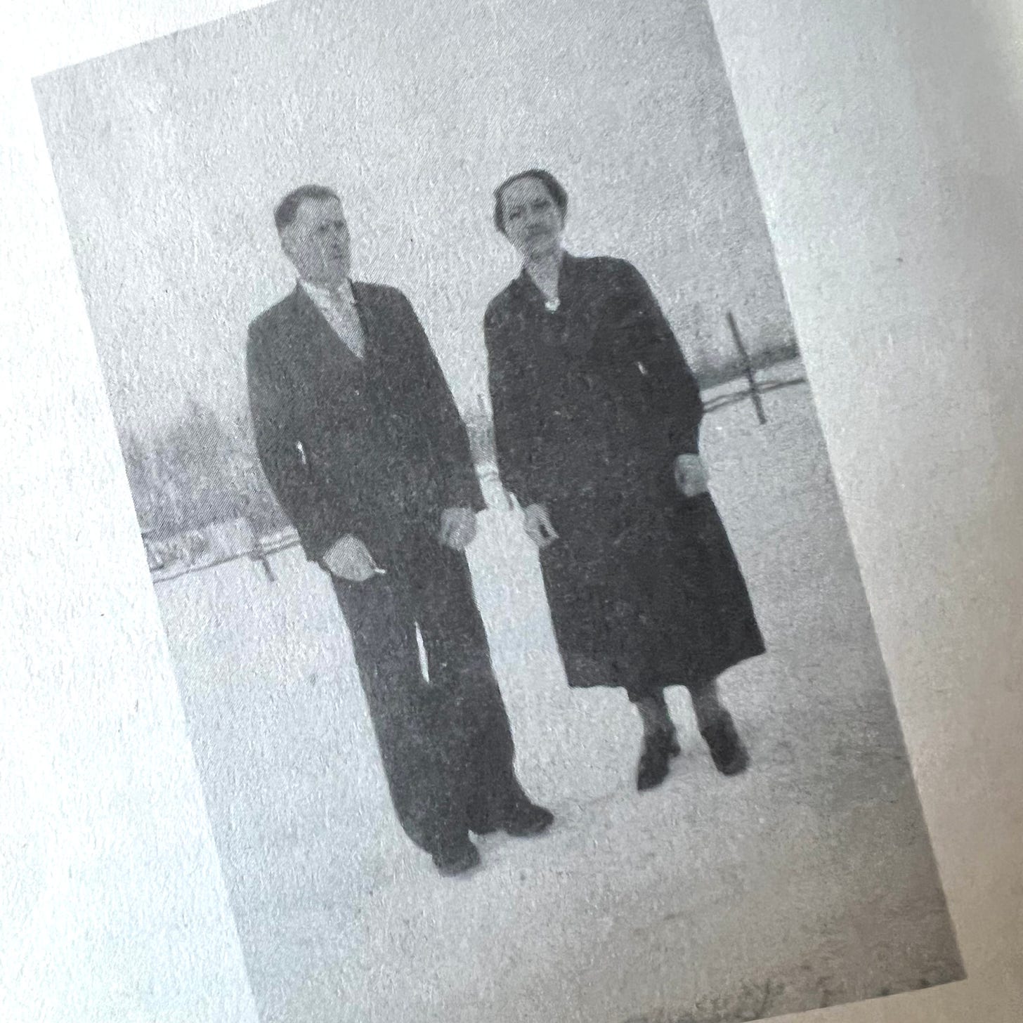 A black and white photo of a man and a woman standing in a frozen field