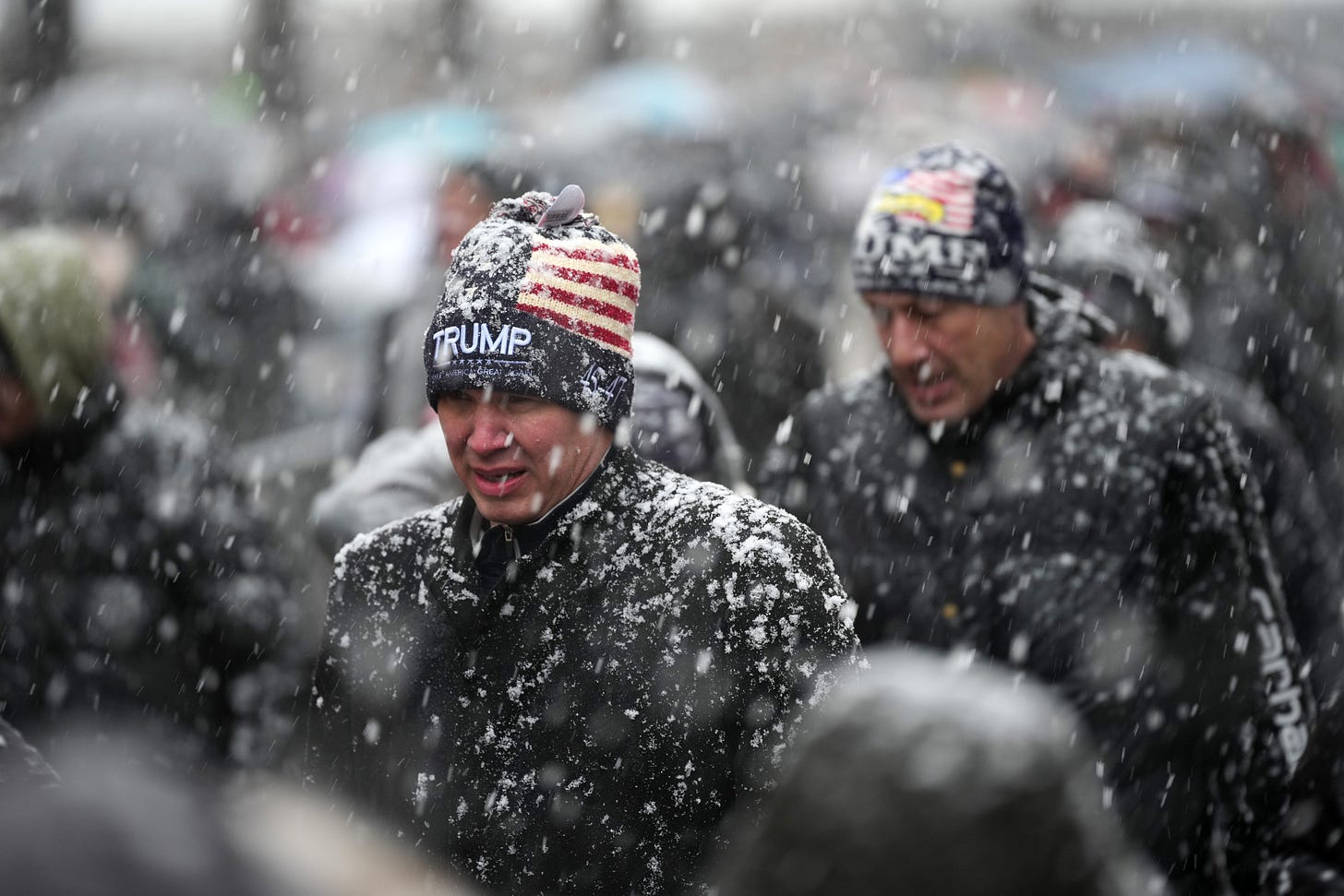 Pessoas fazem fila na neve na Capital One Arena para o comício da vitória de Donald Trump em 19 de janeiro de 2025 em Washington, DC. O presidente eleito dos EUA, Donald Trump, e o vice-presidente eleito, JD Vance, serão empossados ​​em 20 de janeiro. (Foto de Christopher Furlong/Getty Images)