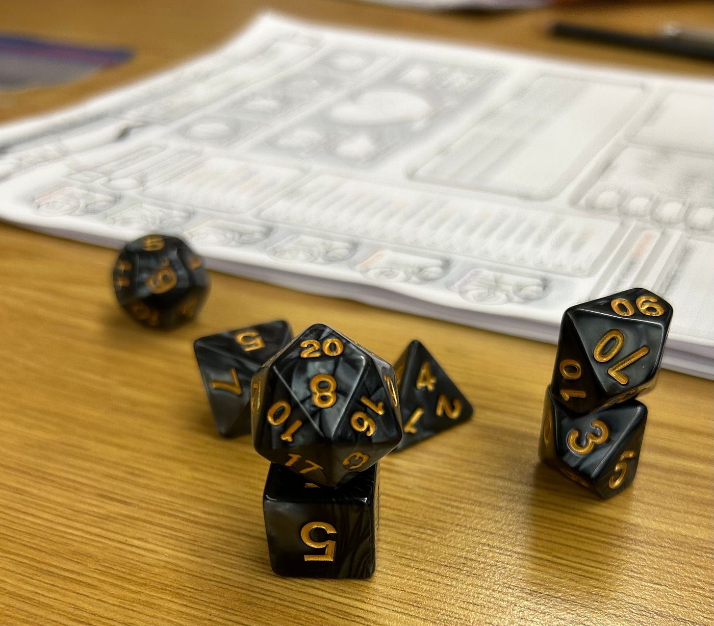 A set of dice for Dungeons and Dragons set in front of a character sheet. The D20 is stacked ontop of a D6.