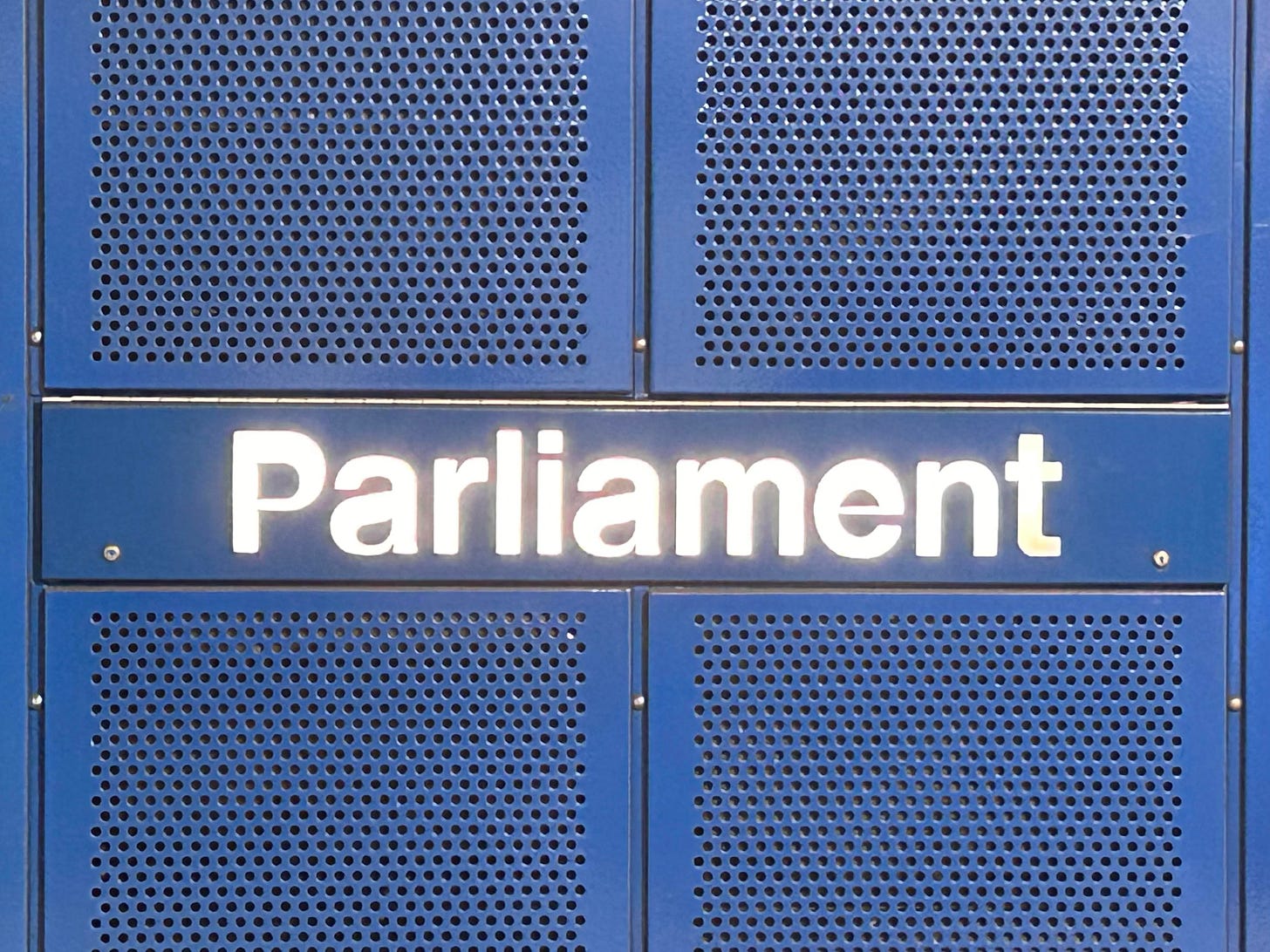 Photograph of the 'Paliament' underground station in Melbourne. The typography is distorted.