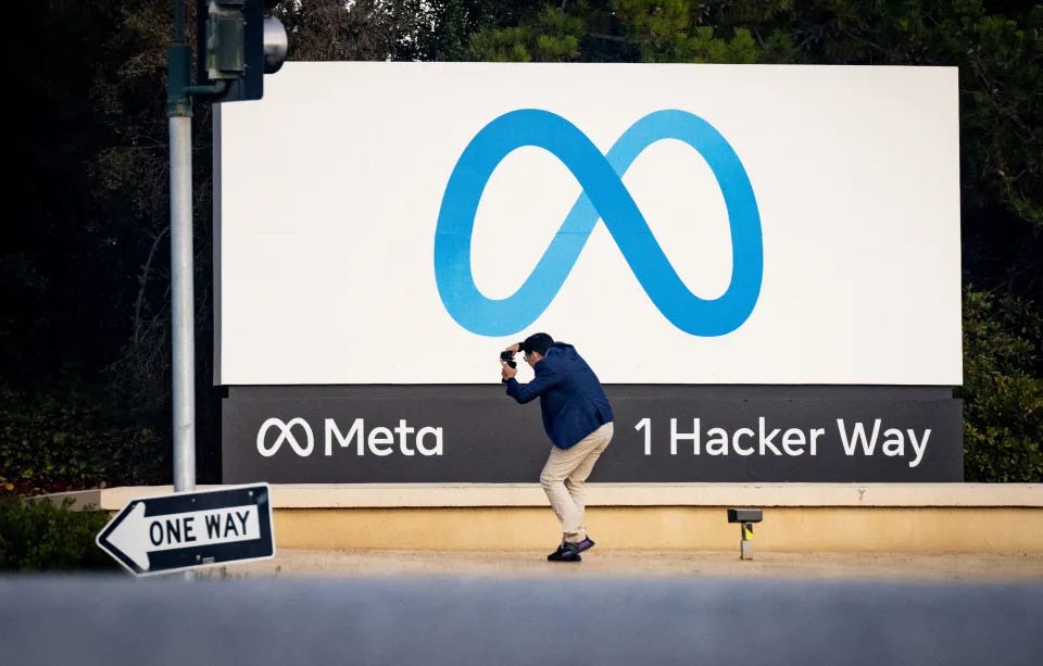 A man takes a photo at Meta (formerly Facebook) corporate headquarters in Menlo Park, California on November 9, 2022. - Facebook owner Meta will lay off more than 11,000 of its staff in 
