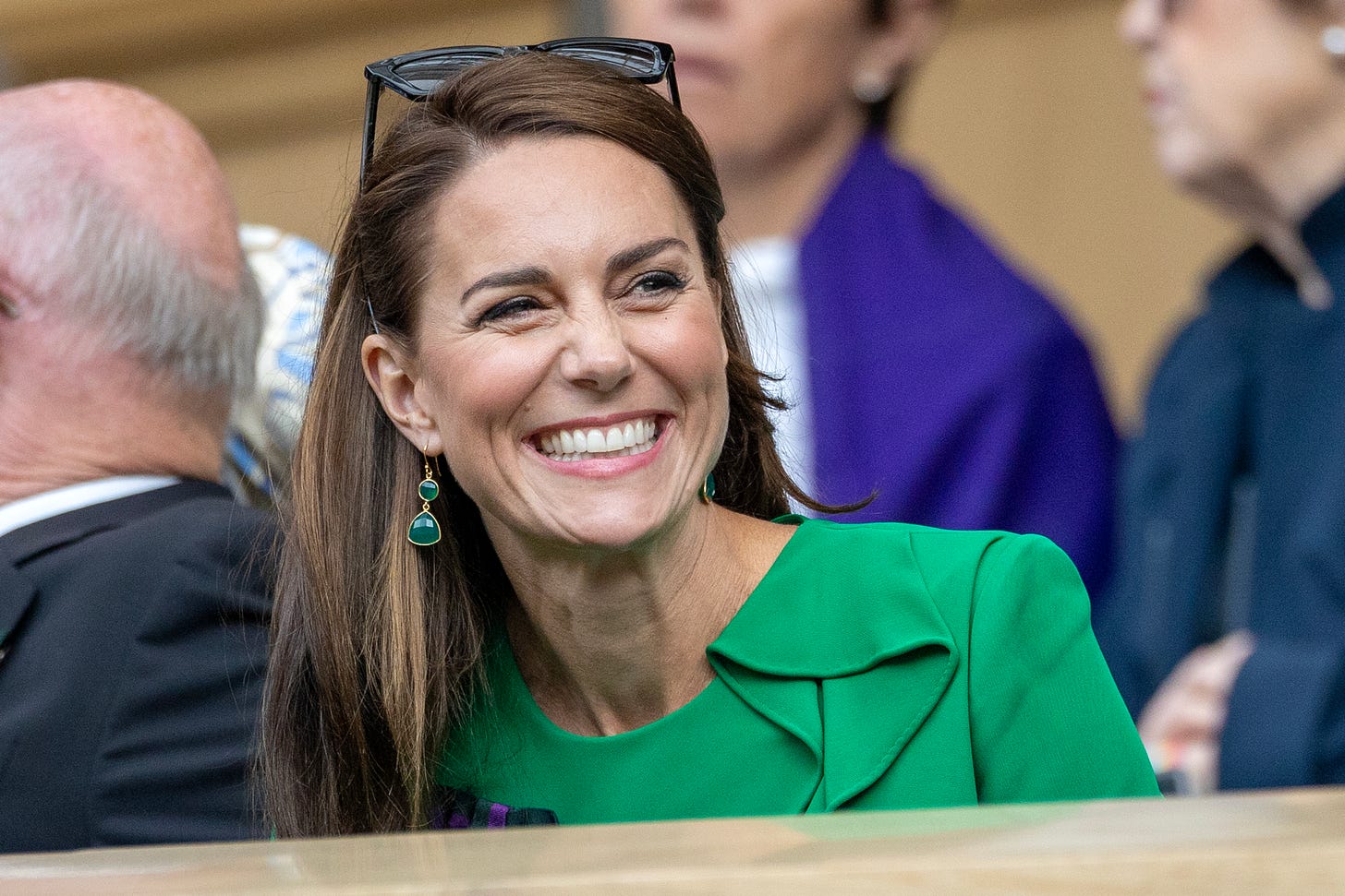 Kate Middleton wearing a green dress and smiling at Wimbledon 2023