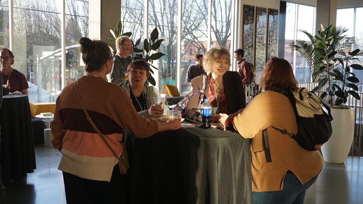 People standing around a cocktail table chatting.