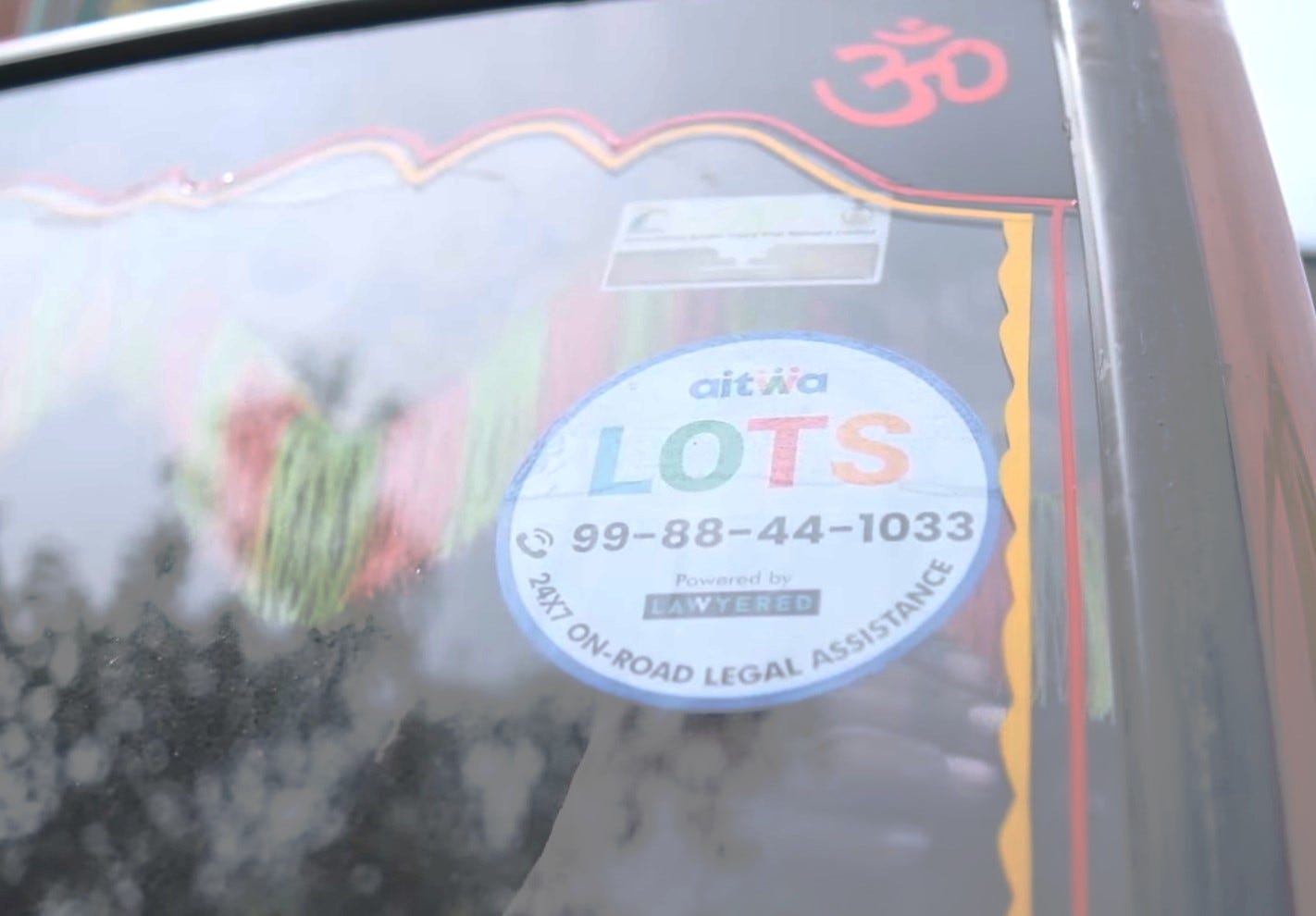 Image of a truck window carrying the sticker for LOTS helpline number