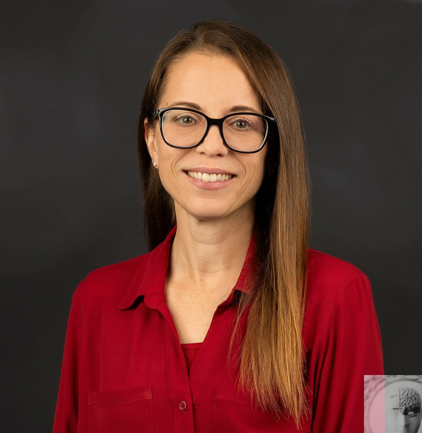 Woman with long blonde hair wearing a red shirt, glasses, and a smile