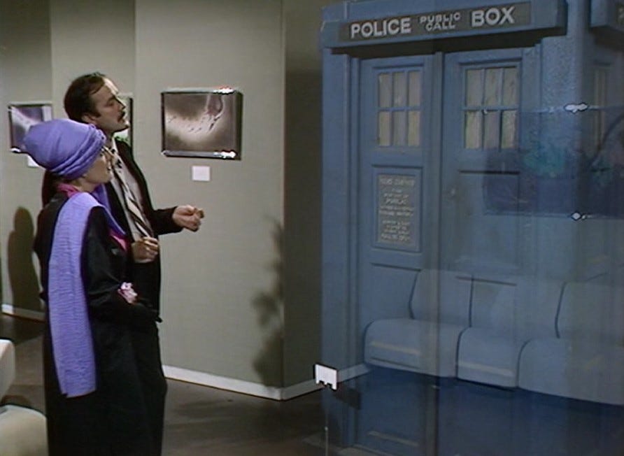 The TARDIS dematerialising in front of Cleese and Bron.