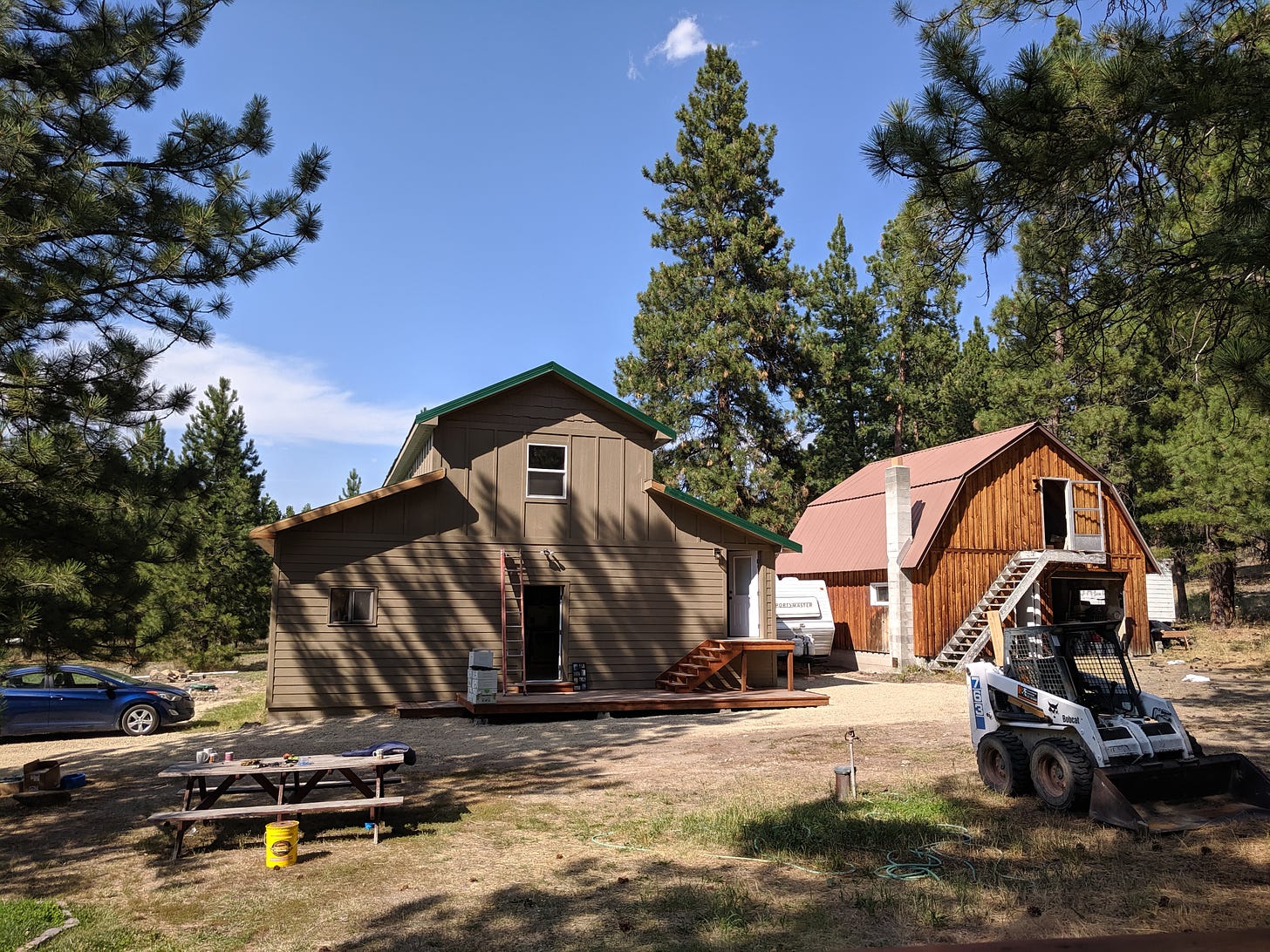 two outbuildings, one a two story wood-shop, and the other a traditional barn with a loft