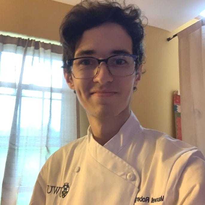 Young man posing proudly in his chef coat