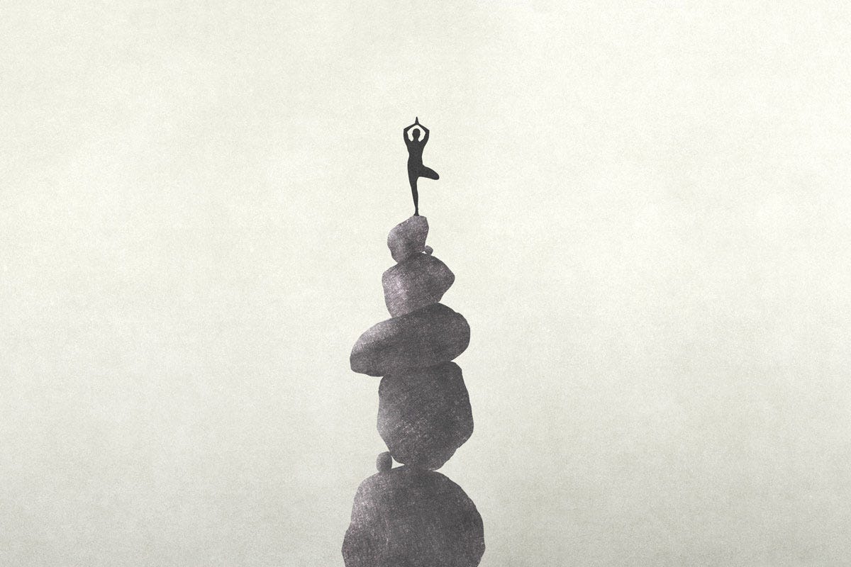 You Cannot Break Us: Person Meditating on Stack of Balanced Rocks