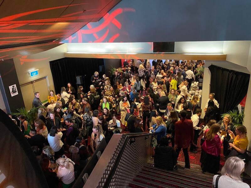 Photo from upstairs at the MoA Electrify Aotearoa Conference, looking down to many women and some men, networking.