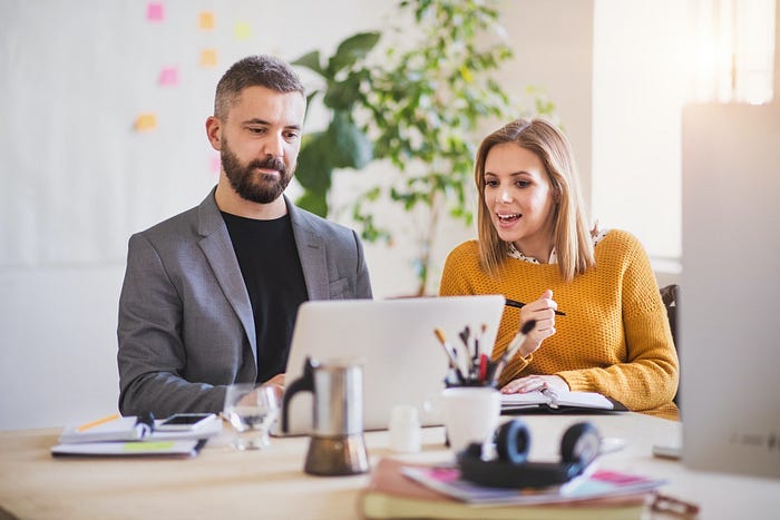 A man and a woman working at a laptop trying to make money online. A man and a woman working at a laptop trying to make money online.