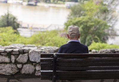 Older man sitting alone on bench