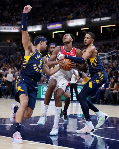 Bilal Coulibaly of the Washington Wizards dribbles the ball while being guarded by Andrew Nembhard and Tyrese Haliburton of the Indiana Pacers in the...
