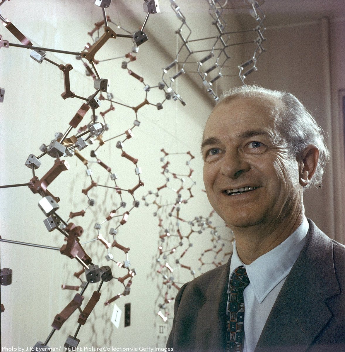 Linus Pauling standing next to a chemical model