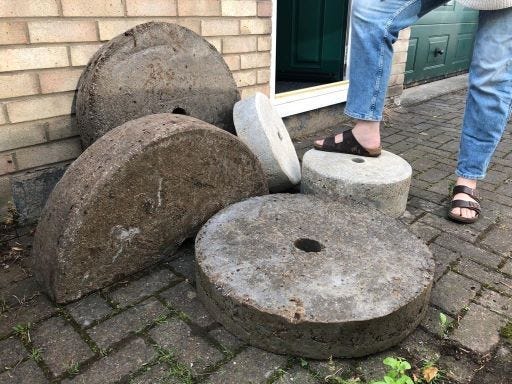 Five homemade millstones are lying on the floor.