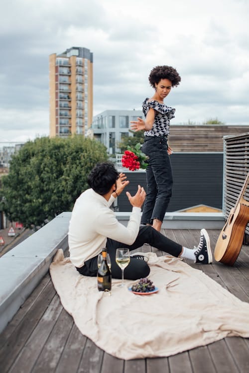 Free Woman Leaving a Man Sitting on Rooftop  Stock Photo