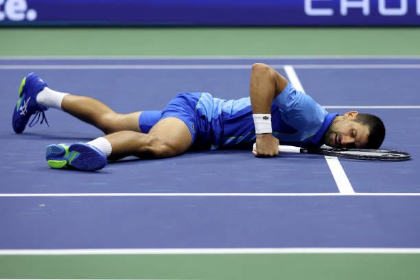Novak Djokovic of Serbia falls down after a point against Daniil Medvedev of Russia during their Men's Singles Final match on Day Fourteen of the...