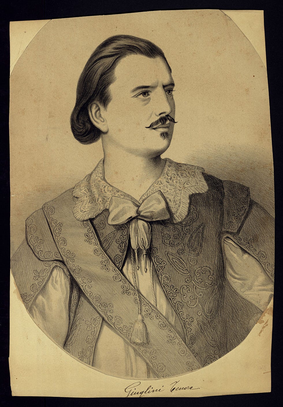 A lithograph of tenor Antonion Giuglini in costume. White man with swept back, long dark hair, moustache and underlip beard. His costume looks as though it's meant to be seventeenth century.