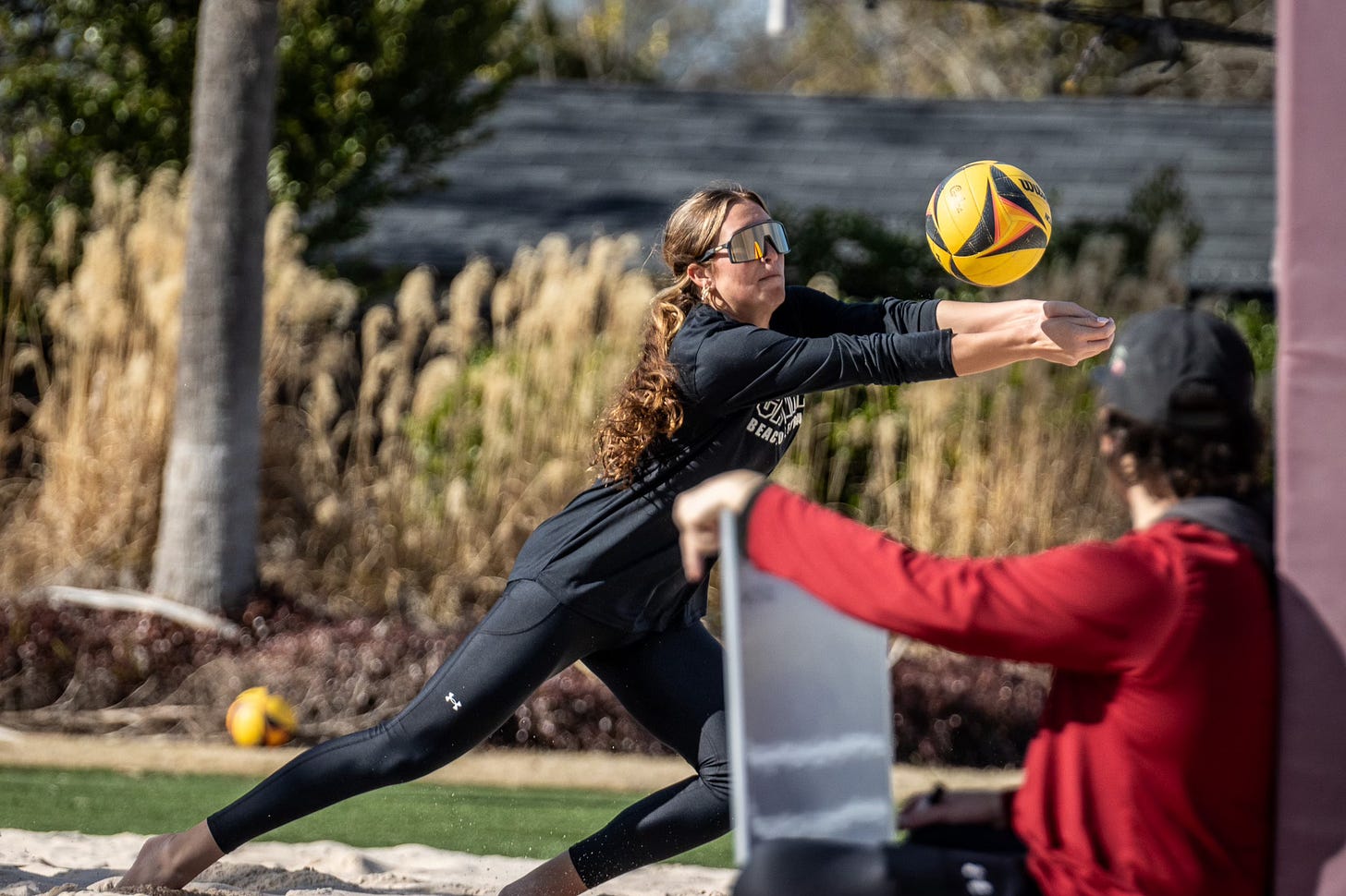 A beach volleyball player moves to the ball