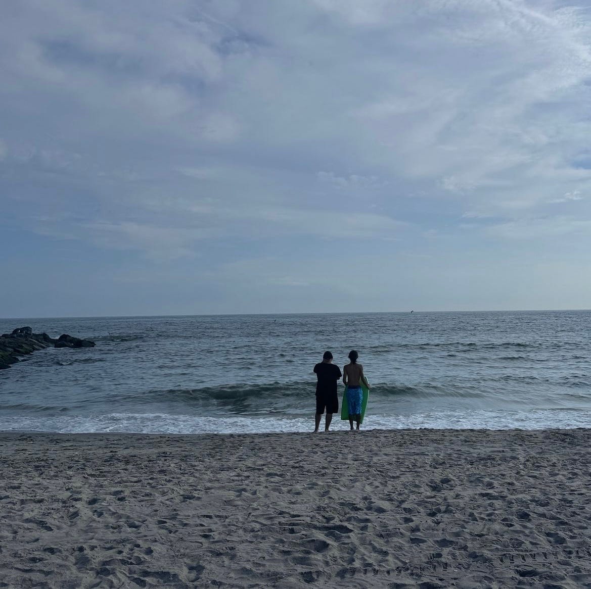 Two people staring at the sea in Rockaways