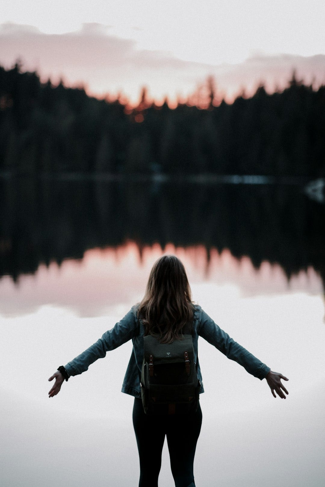woman standing while facing on body of water woman standing while facing on body of water