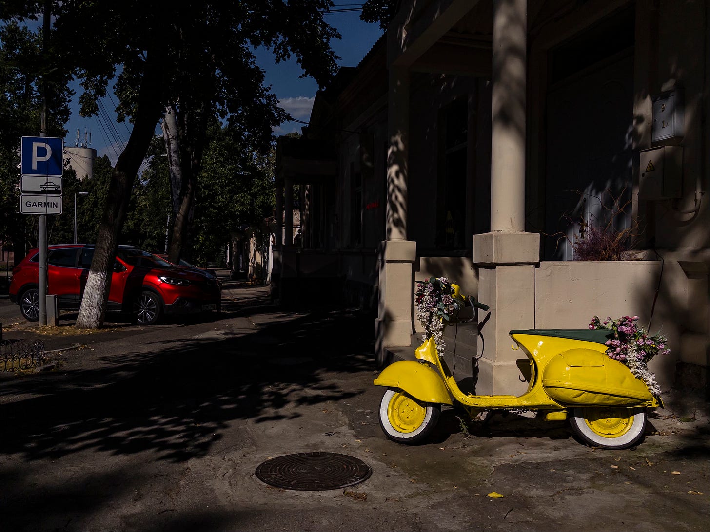 yellow scooter and red car on the streets of Chisinau city centre, Moldova