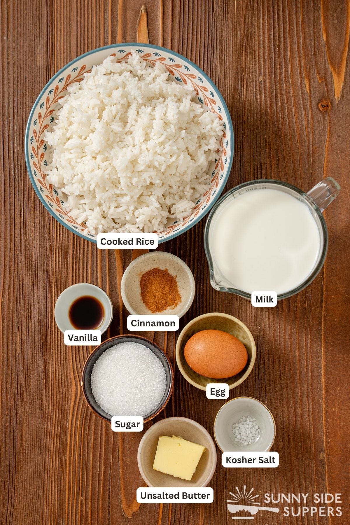 Ingredients for rice pudding on a wood table.