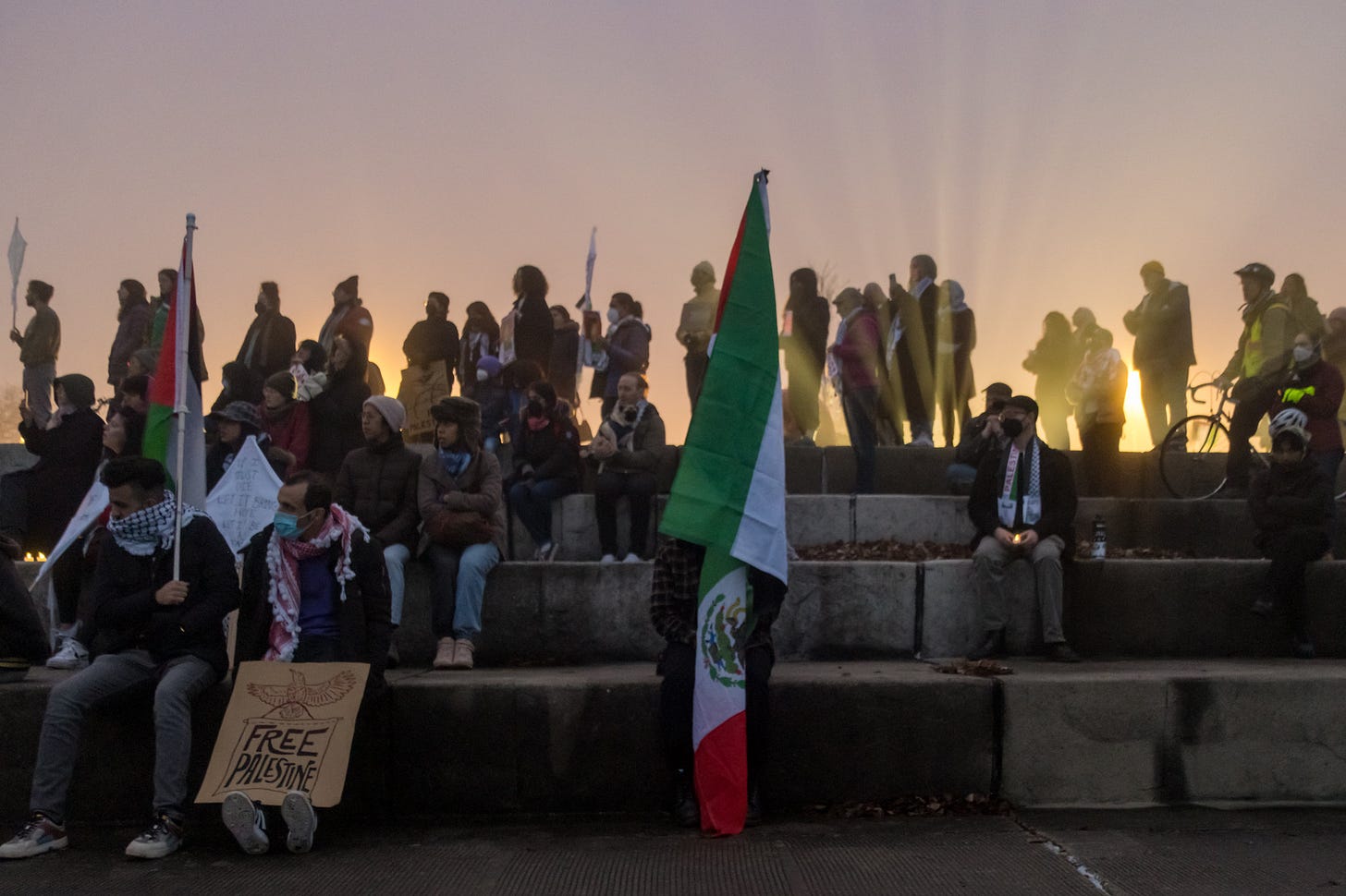 The sun sets behind Palestinian solidarity protesters at Chicago's lakefront.