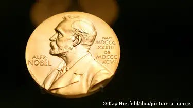A closeup of a golden Nobel Prize with a dark background
