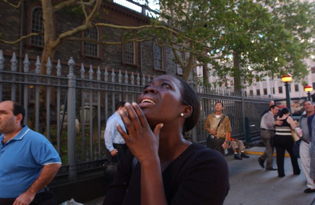 394261 29: A woman reacts in terror as she looks up to see the World Trade Center go up in flames September 11, 2001 in New York City after two airplanes slammed into the twin towers in an alleged terrorist attack. (Photo by Spencer Platt/Getty Images)