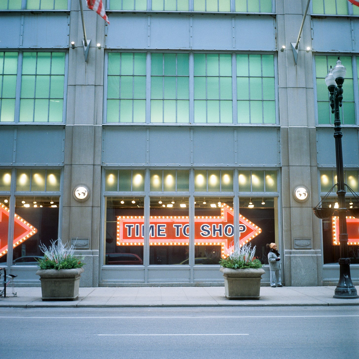 Photo of Chicago storefront with an arrow reading "Time To Shop" in the window
