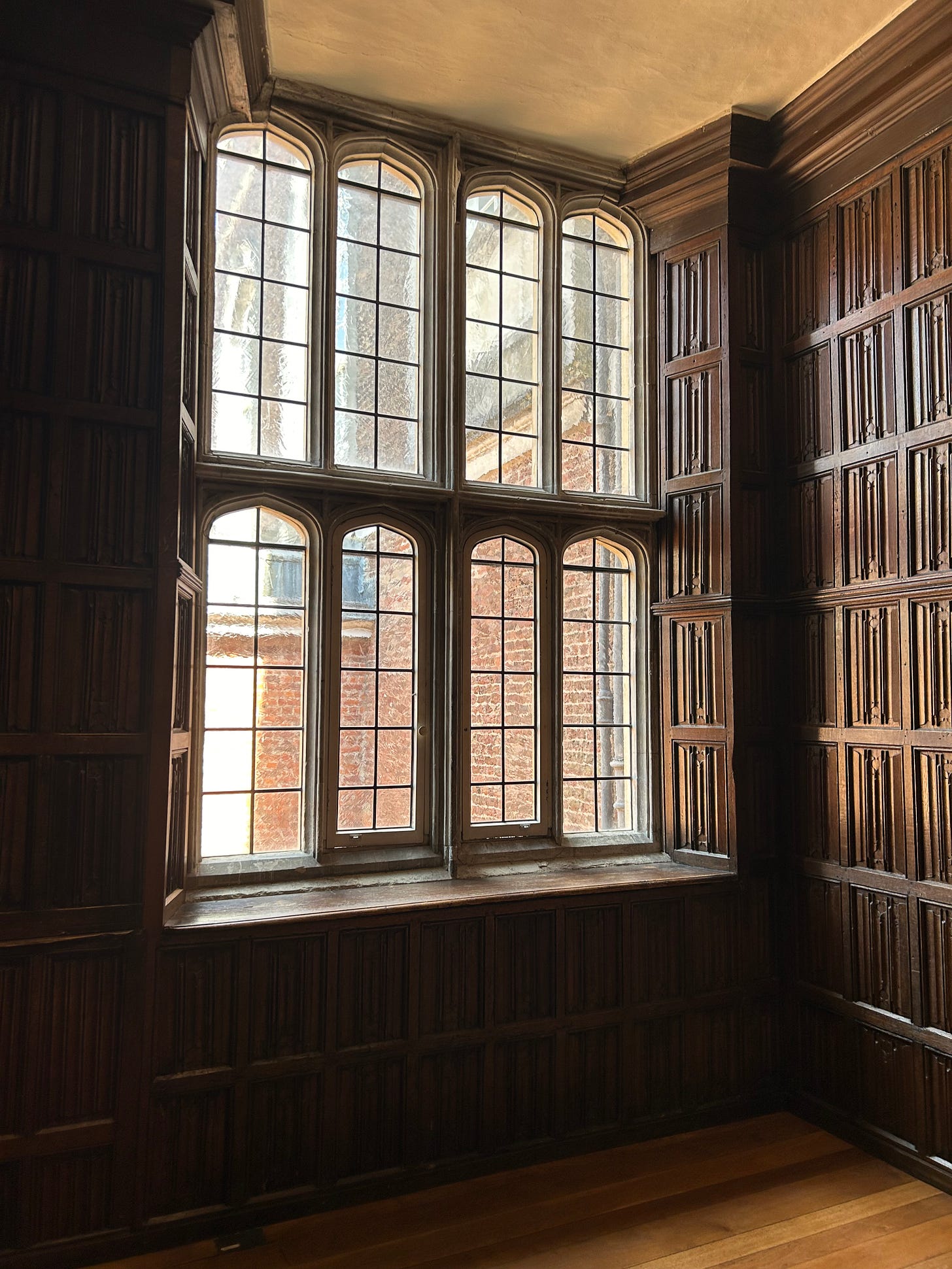 A woodpanelled room, with a large window, divided into eight sections.